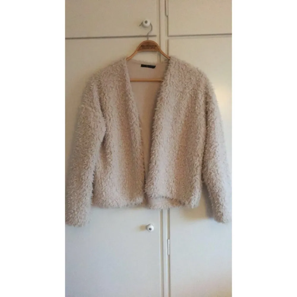 Fluffig, mysig jacka/tröja från Åhléns. Beige/Crémefärgad. Storlek 40/42. Fint skick, från djur- och rökfritt hem! Kan skickas! Se gärna mina andra annonser. :). Jackor.