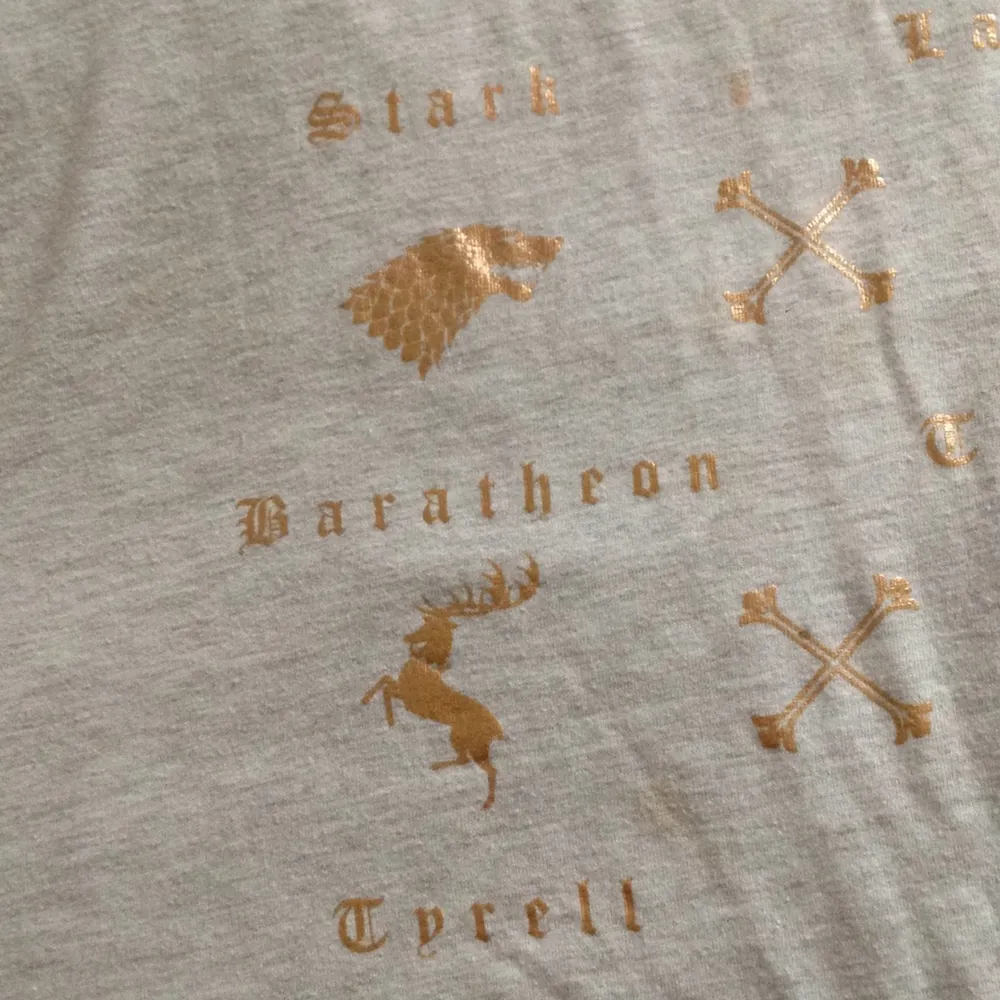 Vilken klan tillhör du? Stark eller Lannister?  En GoT tröja med tryck i ett bronze färg! Perfekt för GoT nörden!. T-shirts.