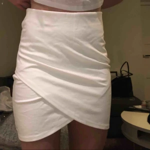  - Vit tight kjol med fin skärning framtill. Säljer likadan i svart. Denna aldrig använd, prislapp kvar! Hör av dig för frågor!