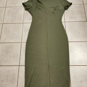 Klänning - Grön klänning från nelly. Lite längre med slits där fram (se bild) storlek s 
