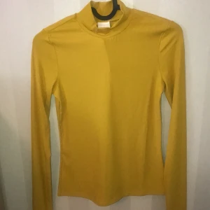 Polotröja  - En polotröja med färgen gul/orange! Jätte luftig och sitter lagomt tajt! Stretchig och den är helt oanvänd! Lappen sitter kvar❣️