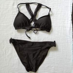 Black bikini in regular fit size 36. Top is padded and ties in the front. Worn for a summer and no damages. 