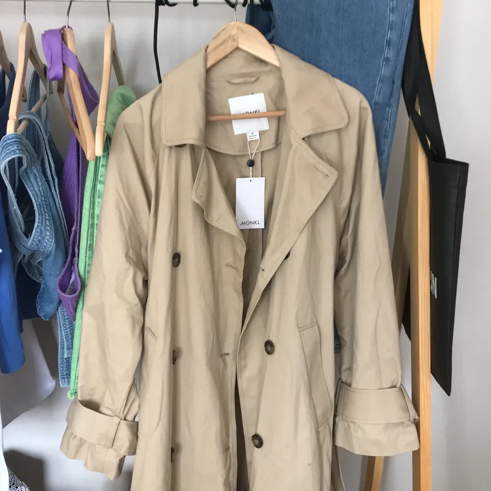 Beige trenchcoat från Monki, aldrig använd och prislapp finns kvar. Nypris 800 kr. Nu 600 kr inklusive frakt.. Jackor.