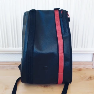 Oanvänd Douchebags-ryggsäck REDEFINED - Oanvänd ryggsäck 15 liter från Jon Olssons märke Douchebags REDEFINED. Slutsåld online. Rymlig och stilren, med röda detaljer i PU läder. 800kr + frakt (93kr). Nypris 1599kr. Samfraktar självklart om du köper mer! 