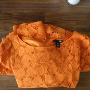 Orange curve-sommarklänning - Sjukt snygg sommarklänning med bra passform tack vare dragkedja i ryggen. Köpt på second hand för 4 år sedan så trots att den är en H&M vågar jag tro att du kommer vara den ändå som bär den! 🍊 Härlig färg och mer vävt material. 