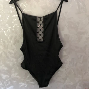 Baddräkt  - Militärgrönt baddräkt med halv låg rygg. Inte sliten eller några fläckar. Juster bara avelbabd. Metal ringar emellan brösten. Dubbel tyg.  frakt 63kr