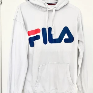 FILA hoodie strl S - Vit hoodie med muddar och märket Fila på bröstet. Köpt på Junkyard. Hoodien är i nyskick och har inte använts många gånger!☺️ Önskas leverans så står köparen för det🌞