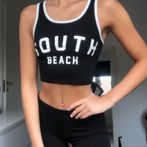 Bik Bok crop top - Crop top från Bik Bok i storleken xs med trycket ”South Beach” på framsidan och 8 på baksidan. Använd ett fåtal gånger, köpare står för fraktkostnad.
