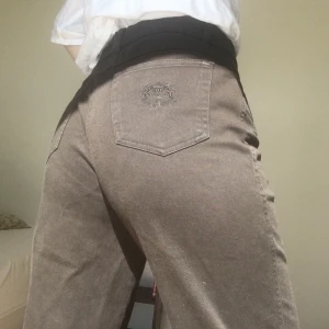 Högmidjade mörkbruna jeans - Jättesköna mörkbruna jeans i rak modell! 🦔 Tunt material och lite stretchigt!🦔  36 cm över midjan, 44 cm över höften och 100 cm lång. 🦔 Säljer pga har växt ur dem :-/  (De är klippta, så lite fransiga, köpta så o har inte sytt upp pga blir för kort på mig