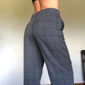 Grå kostymbyxor från Mango, strl 40 - Grå kostymbyxor med svarta streck från Mango, strl 40. Superbekväma men är för stora för mig! Långa raka ben, knappt använda. Köparen står för frakt