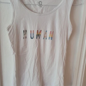 Vitt linne med text - Vitt linne med texten "Human" i olika prideflaggor 🏳️‍🌈 Trycket är påstruket med transfer paper, men har suttit i flera år så ingen risk att det lossnar ⭐ Storlek 158/164 men kan ses som XS. Kontakta vid frågor/intresse 💜 frakt inräknad