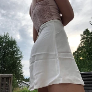 Kjol - Tunn, vit, tyg kjol med 6st knappar i fram samt en dragkedja i bak🌟 En välanvänd kjol, därmed sitt låga pris. Köparen står för frakt!                        Stolek: Xs/S.      Märke: Tammy
