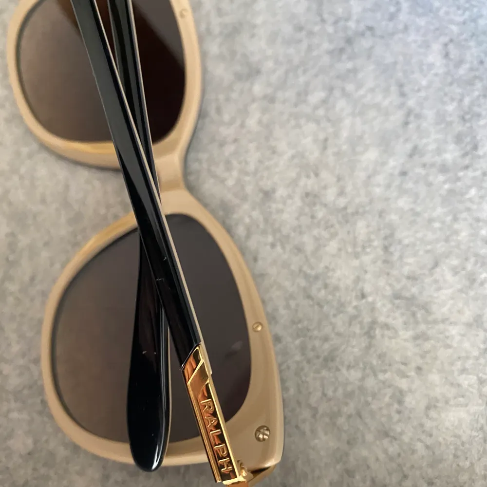 Knappt använda, äkta solglasögon från Ralph Lauren med guldiga och beiga detaljer. Modellen är lite cateye likande vilket är väldigt snyggt enligt mig. Nypris: ca 1100kr. Accessoarer.