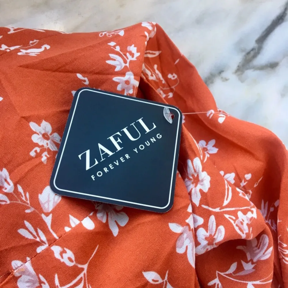 HELT NY med lappen kvar! Jättegullig röd/orange blommig omlottklänning i storlek S från Zaful. Det är en knytning i sidan så man kan justera den hur man vill!🧡. Klänningar.