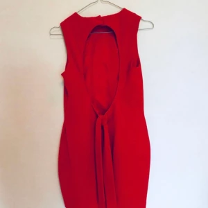 Festklänning! - Frakt ingår!   Härlig röd cocktailklänning från ASOS. Ganska kort, hög i halsen, och min favvodetalj: öppen rygg med band att knyta en rosett. Väldigt välsydd och lyxig med lite tjockare tyg utåt och silkig underklänning. Använd 2ggr, är en liten 38a. 