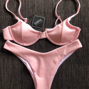 Oanvänd zaful bikini ljusrosa ribbad  - Säljer min oanvända zaful bikini i ett ribbad ljusrosa tyg. Bra kvalitet med justerbara axelband. Säljer pga fel storlek. Storlek M. Frakt tillkommer på 45kr. 