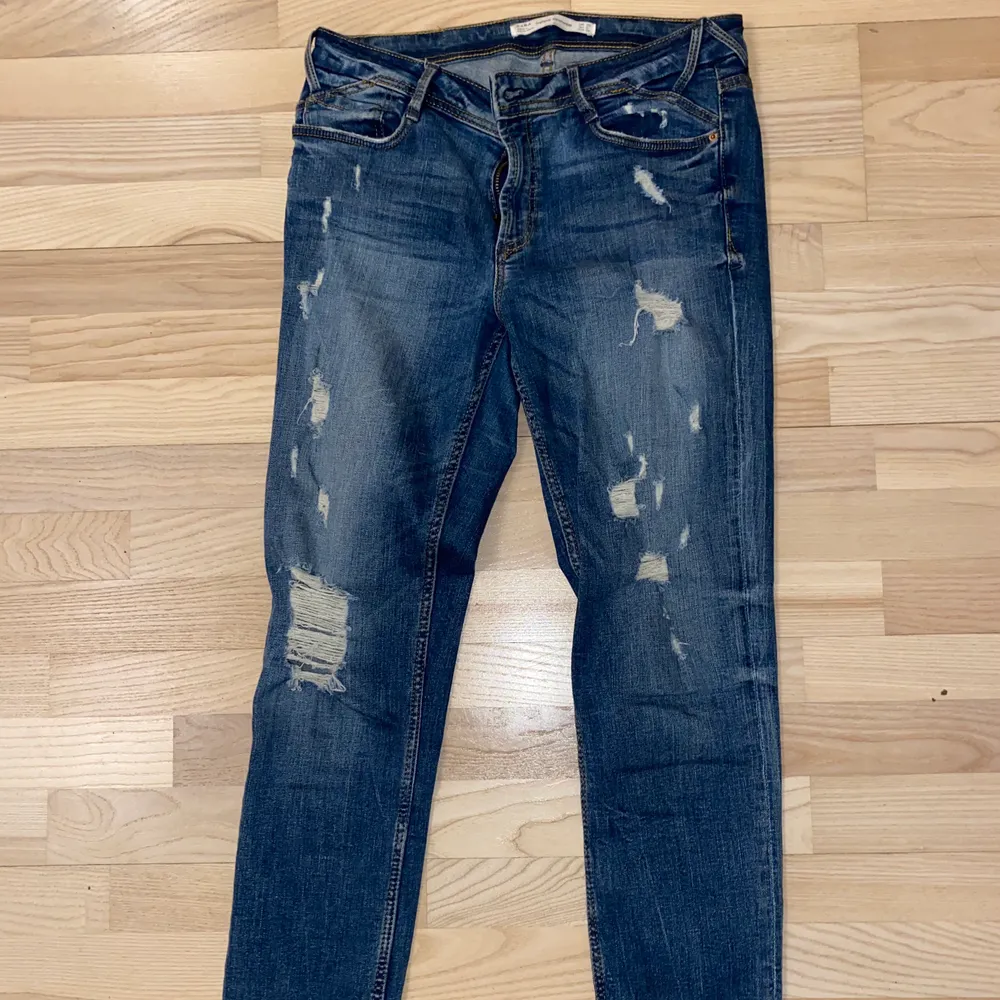 Jeans med slitna detaljer från Zara i storlek 38. En tightare modell med stretch. Jeansen är i fint skick. Köparen står för frakten 💞. Jeans & Byxor.