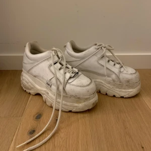 Buffalo London classic low white 38 - Säljer mina coola buffalos med hög sula. Lätta att gå i trots den höga sulan! Använd en sommar väldigt väl som man ser. Ytsmuts på skorna går att tvätta bort enkelt med specefik skotvätt. Säljer pga att dem stått oanvända sen ett år tillbaka. Nypris: 900