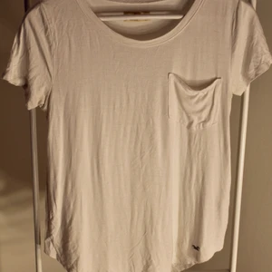 Vit Hollister T-shirt - Vit Hollister T-shirt i fint skick! storlek: XS Direkt pris: 35kr, Skriv buden till mig privat eller kommentera på bilden! Buda med minst 5kr varje gång ✨(Alla bud är välkomna) Köpare står för frakten (Du bestämmer vilket paket så länge det uppfyller vikt och storleks kraven)