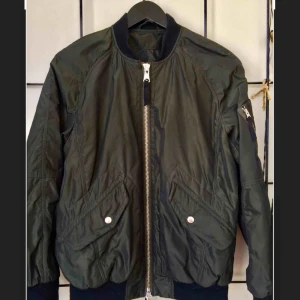 - - Bomberjacka från J Lindeberg - Dam, strl 36 - Färg mörkgrön - Dragkedja framtill - Sidofickor med dragkedja - Mudd vid hals, i ärmslut och i nedkant - Fodrad - Längd ca 57 cm 