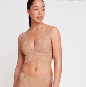 En riktigt bekväm och samtidigt vacker bralette täckt av mjuk spets. De bygellösa kuporna har en tunn vaddering. färgen är rosa inte beige. Bra skick.