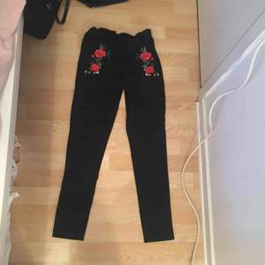 Svarta byxor med röda blommor 