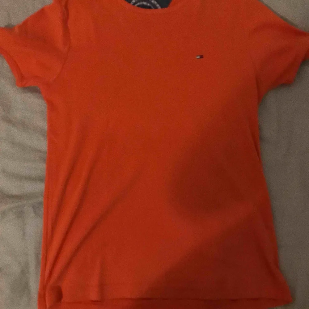En orange t-shirt från tommy hilfiger, använd 1 gång. Frakt 40kr eller mötas upp inom stockholm. . T-shirts.