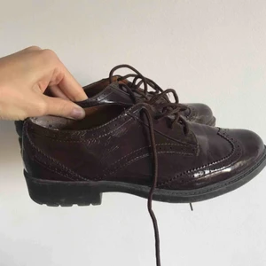  - Skor från i London, dessvärre står ingen storlek, men de passar mig som brukar ha skor i storlek 38/39. Mörkröd färg och snören i samma färg, i glansigt material. Priset inkluderar inte frakt. Använda ca 1-2 gånger, men skicket är väldigt bra. 