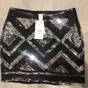  - Kjol med paljetter med etiketter kvar. 