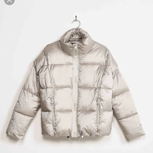  - Silvrig dunjacka med text vid dragkedjan! Använd litegrann men i bra skick! Skicka meddelande för fler bilder :) Pris exklusive frakt!