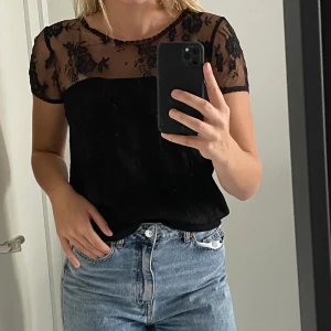 Svart Spets T-shirt  - Svart skitcool T-shirt med spets från Ida Sjöstedt. Snygg & lätt att styla snyggt. 