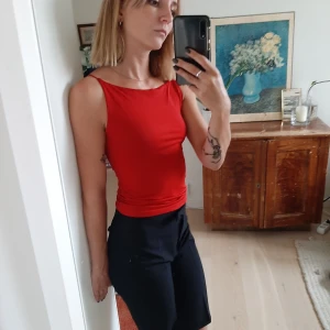 Tight rött linne med tunna band - Säljer mitt fina röda linne (är mer blodrött än tomatrött, svårt att fånga på bild), superstretchigt tyg som sitter tight intill kroppen, med elastiska små band vid axlarna. Superskönt att bära! Frakt ingår i priset:))