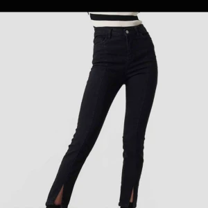  - Jeans från NA-KD med söm i mitten och slits längst ner. Storlek 40.