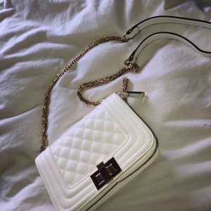  - Vit väska, med gulddetaljer, använd 4-5 gånger, småmärken på låset annars är den bara i fint o rent skick.