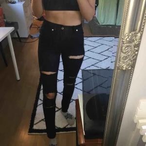  - Svarta slitna jeans med många hål. Frakt tillkommer