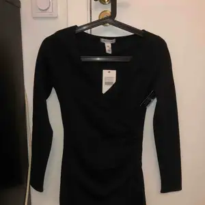 En svart ”wrap” klänning från Nelly Aldrig använd