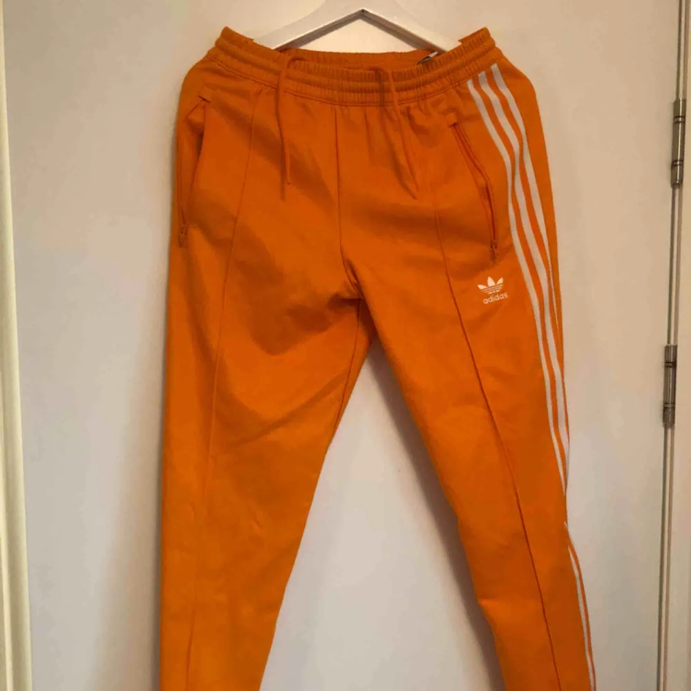 Fräsch orange Adidas tracksuit-byxor i storlek M! Använd 1 gång! Nypris ligger på 700kr. Kan mötas upp eller köra på frakt. Frakt ligger dock på köpare.. Jeans & Byxor.