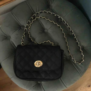  - Jätte fin väska i svart med gulddetaljer. Köpt för 300kr. Använd fåtal gånger.   Fraktar eller möts upp i centrala Stockholm