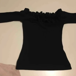  - En offshoulder tröja med volang helt ny aldrig använd från Nelly 
