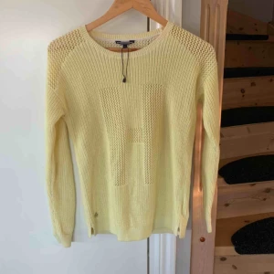  - Gul stickad tröja från Tommy Hilfiger. Ett H fram på tröjan. Helt oanvänd. Hör av dig om du undrar något.