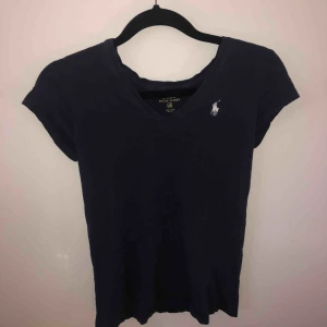  - Begagnad Ralph Lauren polo t-shirt. Snålt använd, mycket fint skick. Några år gammal. Storlek: XS Färg: mörkblå 