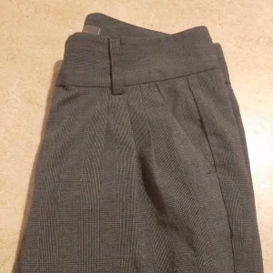  - Smårutiga kostymbyxor. Stl 36. 50kr.