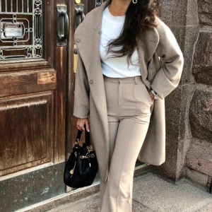  - En beige kappa med orangt foder 