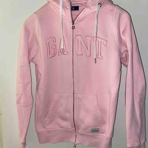 Jag säljer en rosa hoodie från märket Gant, den är inköpt på johnells i Uppsala.  Storlek: XS Nypris: 1299 :- Bud från 200:- Den kommer från ett djur och rökfritt hem.