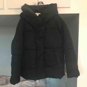  - Svart puffig jacka från hm med stor mysig luva. Knapparna sitter lite löst men går att sy fast lätt!  Jag har använt den som vinterjacka (varm) förra året men fortfarande i fint skick! 