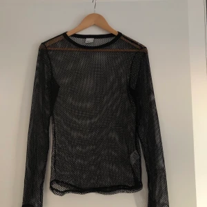 Svart nättröja - Svart ”nättröja”, strl M. Oanvänd och bra skick. Skulle vara snyggt under en t-shirt eller liknande. Köparen står för frakt.