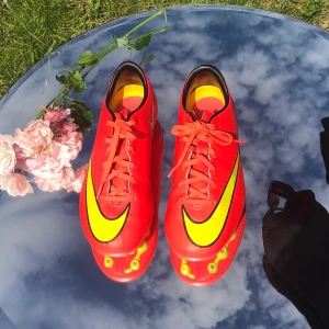 Nike fotbollsskor  - 💖Säljer mina fotbollsskor från Nike i mycket bra skick för ett mkt billigare pris. Optimalt för konstgräs. Originalpris runt 900kr. Färg: Stark rosa/orange och gul. Inkluderar ankelskydd
