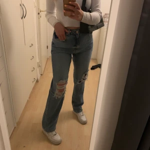NAKD distressted straight fit jeans - Oanvända nakd jeans med hål i, dessa är endast provade vilket ni kan se på bilden. Säljer på grund av förstora i midjan. Storlek 40 men passar troligtvist även en 38. Jag är 171cm. Köparen står för frakt, kan även mötas i uppsala och Stockholm.