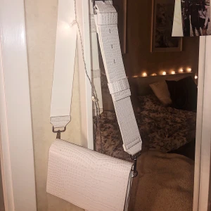 Axelbands väska  - Vit axelbandsväska från Carin Wester i orm mönster,använd fåtal gånger därav bra skick 