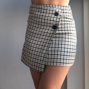 Rutig kjol - Säljer min rutiga kjol från HM, endast använd en gång, har två knappar i fram med en överlappning, storlek 34, men passar mig som normalt är 36